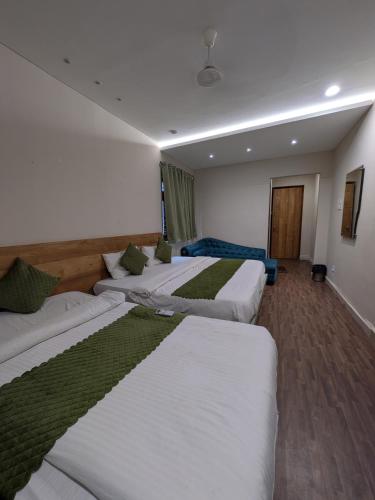 a hotel room with four beds in a row at Hotel Petal Inn in Nagpur