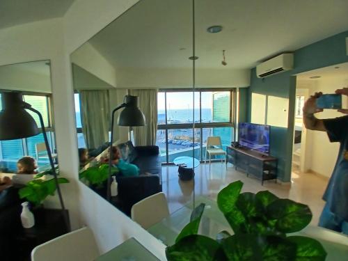 a person taking a picture of a living room at מלון אוקיינוס במרינה שני חדרי שינה in Herzliyya B
