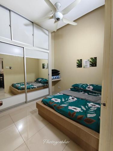 a bedroom with two beds and a ceiling fan at Laman Baraqah in Kuantan
