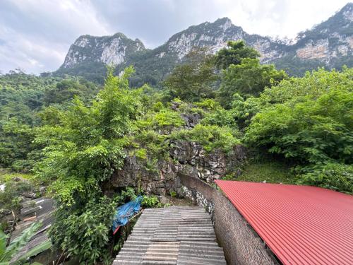 a wooden walkway with mountains in the background at Ba Be Lake - Nhà Nghỉ Thư Nhạc in Bak Kan