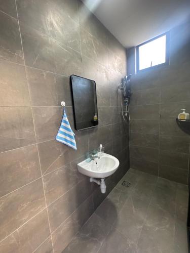 a bathroom with a sink and a mirror on the wall at RTS - BluLake Guesthouse Tasik Biru Bau in Bau