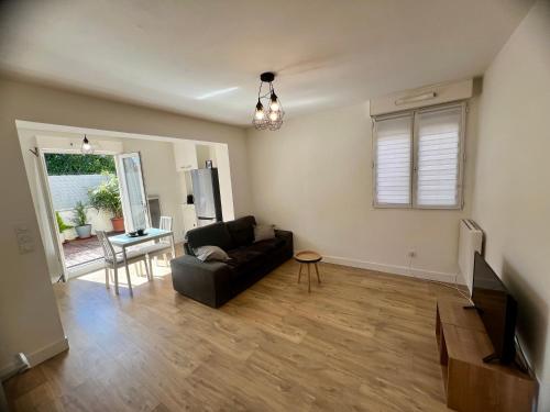 a living room with a black couch and a table at Magnifique appartement à IGNY proche Saclay, Massy, Versailles, Paris in Igny