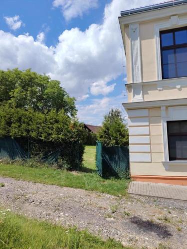 a house with a fence next to a field at Penzion Zamecek in Uherčice