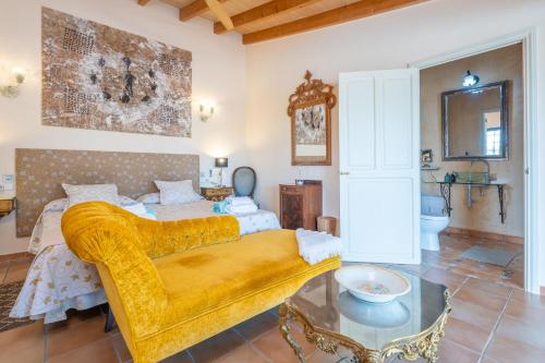 a bedroom with a bed and a yellow couch at Banc Doli in Manacor