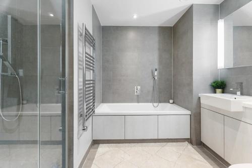 a bathroom with a tub and a sink and a shower at Luxury 2 BR Riverview Ensuite Flat in Greenwich Near O2&Excel in London