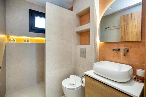 a bathroom with a sink and a toilet at Emmeli's de lux apartments in Skala Marion