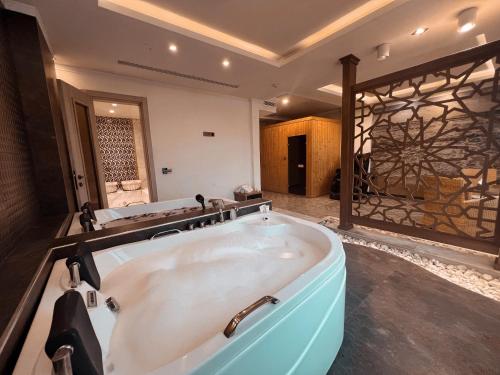 a bathroom with a bath tub in a room at Nova Sky Hotel in Erbil