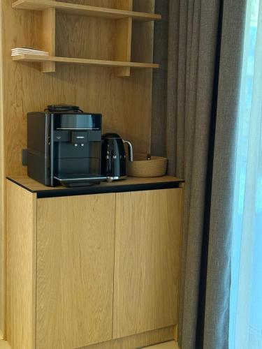 a kitchen with a microwave and a printer on a shelf at GirskiDelux in Bukovel