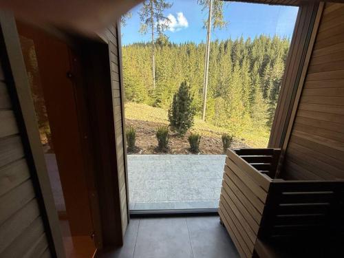 a room with a large window with a view of a forest at GirskiDelux in Bukovel