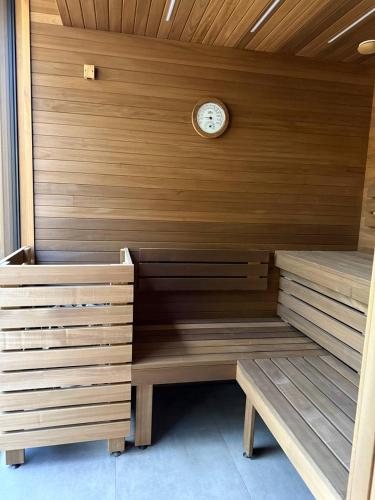 a sauna with a clock on a wooden wall at GirskiDelux in Bukovel
