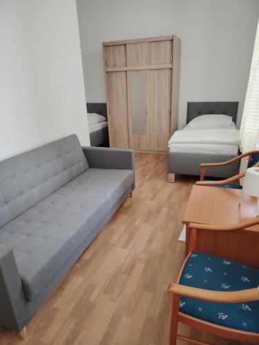 a living room with a couch and a bed at Penzion Zamecek in Uherčice