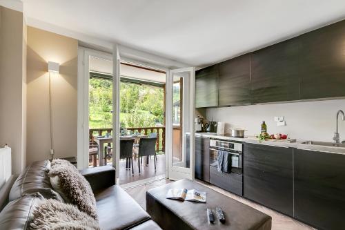 a living room with a couch and a kitchen at Boutique Apartment Limone Ski In Ski Out - Happy Rentals in Limone Piemonte