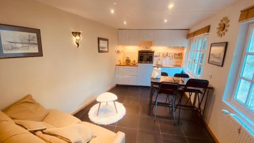 un salon avec un canapé et une table et une cuisine dans l'établissement La Tour de Flandre, à Rousseloy
