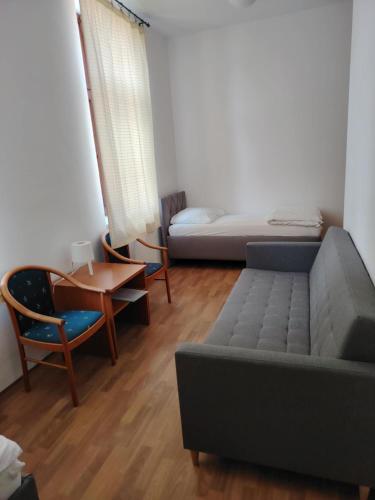 a living room with a couch and a bed and a table at Penzion Zamecek in Uherčice