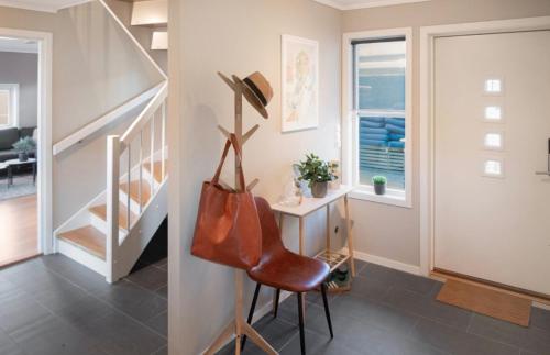 a living room with a staircase and a chair at Spacious house in a quiet neighborhood in Halden