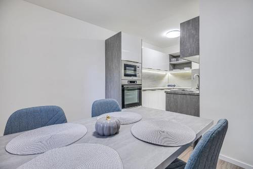 a dining room with a table and blue chairs at Nitra Castle Suite - Modern Elegance & Serenity in Nitra