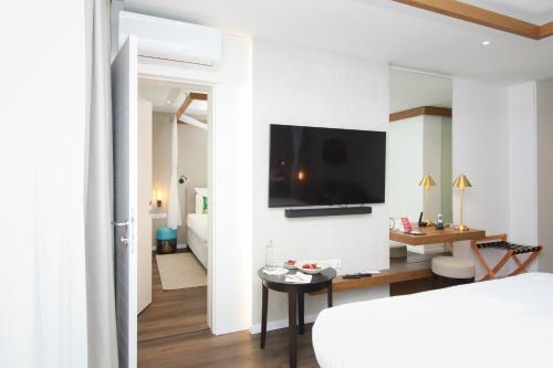 a living room with a tv on a white wall at Mövenpick Balaland Resort Lake Balaton in Szántód