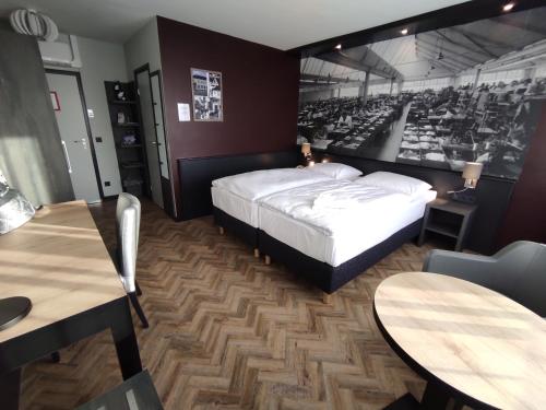 a bedroom with a bed and two tables and chairs at Akzent City-Hotel Kleve in Kleve