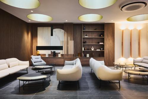 a lobby with couches and chairs and a television at voco Katowice by IHG in Katowice