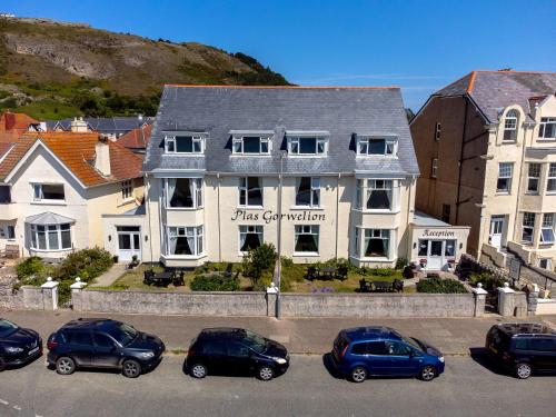 a building with cars parked in a parking lot at Plas Gorwelion guest house - Adult only in Llandudno