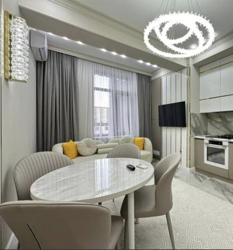 a living room with a table and a couch at Квартира Оксижен в жк Парк Авеню in Bishkek
