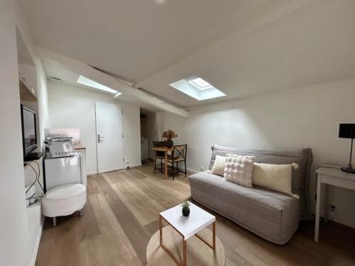 un salon avec un canapé et une table dans l'établissement Studio meublé, à Chasselay
