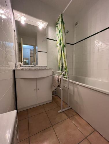 a bathroom with a tub and a sink and a bath tub at Appartement 6 couchages proche des pistes et commerces in Les Angles