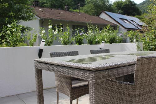 a wicker table and chairs on a patio at Ferienwohnung Jungpfalzstieg in Rinnthal
