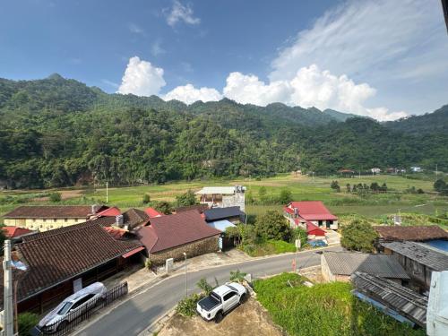 a view of a village with cars parked on a road at Ba Be Lake - Nhà Nghỉ Thư Nhạc in Bak Kan