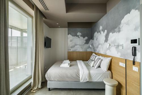 a bedroom with a bed with a painting on the wall at Rezident Tomis Marina in Constanţa