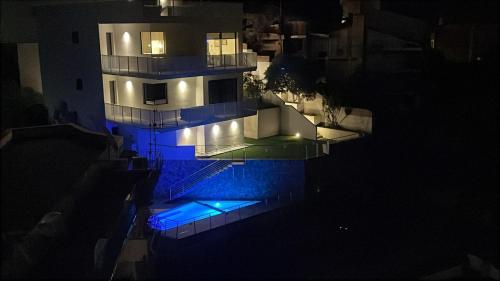 an aerial view of a building at night with blue lights at Casa DiMa - La Pigna Verde in Taormina