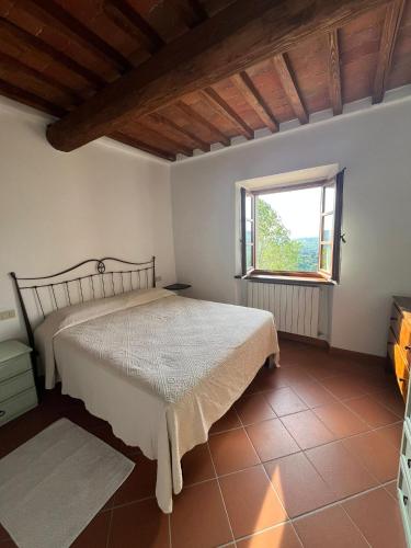 a bedroom with a bed and a window at Appartamento Bellavista in Radda in Chianti