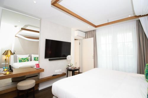 a hotel room with a bed and a television at Mövenpick Balaland Resort Lake Balaton in Szántód