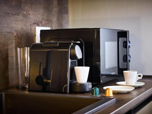 a coffee maker sitting on a counter with two cups at The School Venice, boutique Loft in Venice