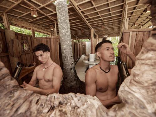 two shirtless men sitting in a bath tub at The Survival by Seudam in Ko Kood
