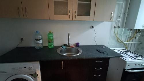 a kitchen counter with a sink and a stove at APARTMENT Lib House center Beltsy in Bălţi