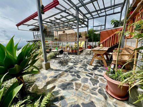 a patio with potted plants and a pergola at La Puesta Del Sol in Filandia