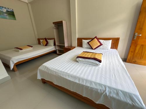 a bedroom with two beds with white sheets at Ba Be Lake - Nhà Nghỉ Thư Nhạc in Bak Kan