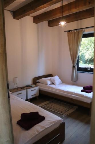 two beds in a room with a window at Agroturystyka BieszCzadowa Dolina Cisna in Cisna