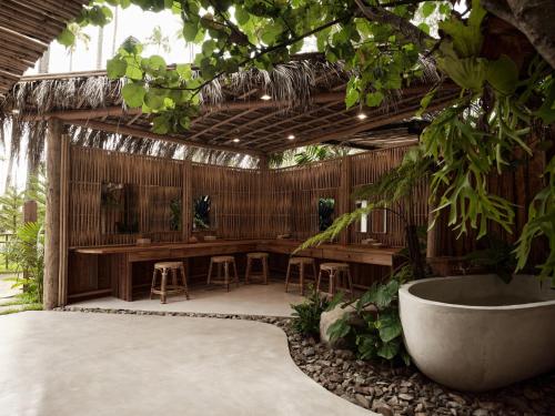 an outdoor room with a table and chairs and a tub at The Survival by Seudam in Ko Kood