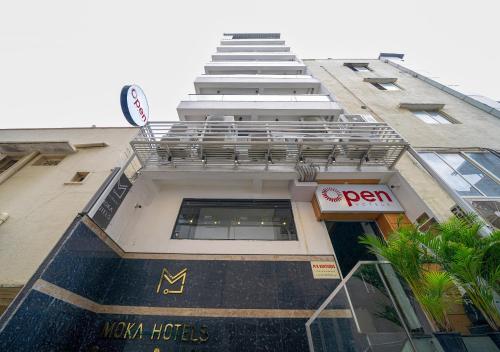 a tall building with a balcony on top of it at Open Hotel by Olive - Moka in Bengaluru