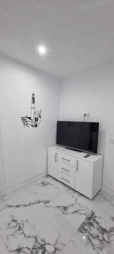 a living room with a television and a white wall at Victory in Alicante