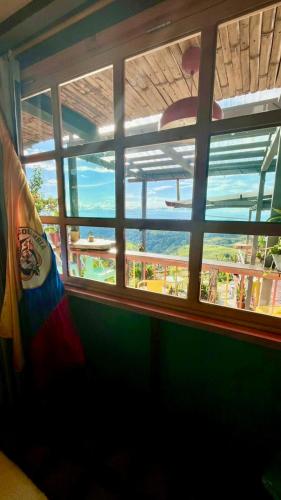 a window with a view of the beach through it at La Puesta Del Sol in Filandia