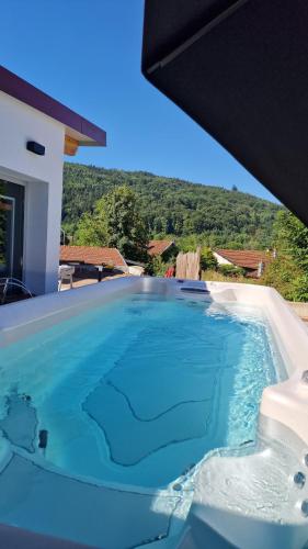 a large swimming pool with blue water in a house at Le Domaine de la Répandise in Laveline-du-Houx