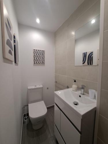 a white bathroom with a toilet and a sink at Habitación en el centro histórico de Tarragona in Tarragona