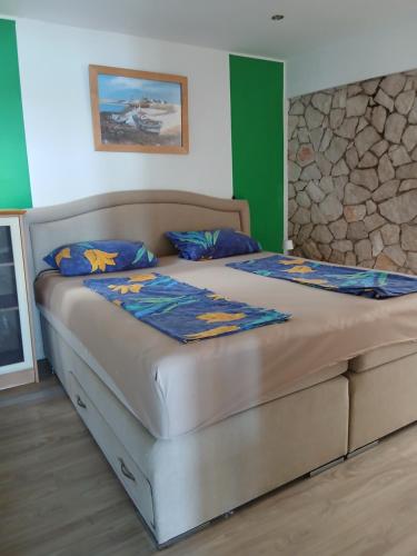 een slaapkamer met een groot bed met blauwe kussens bij Apartmenthaus Kornatiblick in Tisno