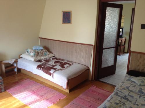 1 dormitorio con 1 cama y puerta a una habitación en Szőnyi úti vendégház, en Zebegény