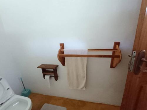 a bathroom with a toilet and a towel on a wall at mafiakivulinilodge in Utende