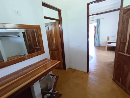 a room with a mirror and a wooden table at mafiakivulinilodge in Utende