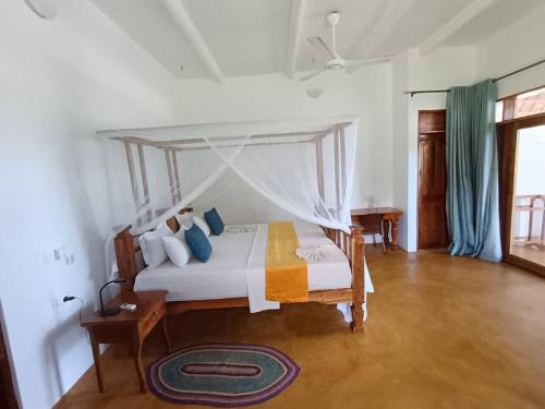 a bedroom with a bed with a canopy at mafiakivulinilodge in Utende